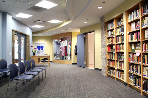 The lobby of the library, with a row of chairs and a bookcase to the right.